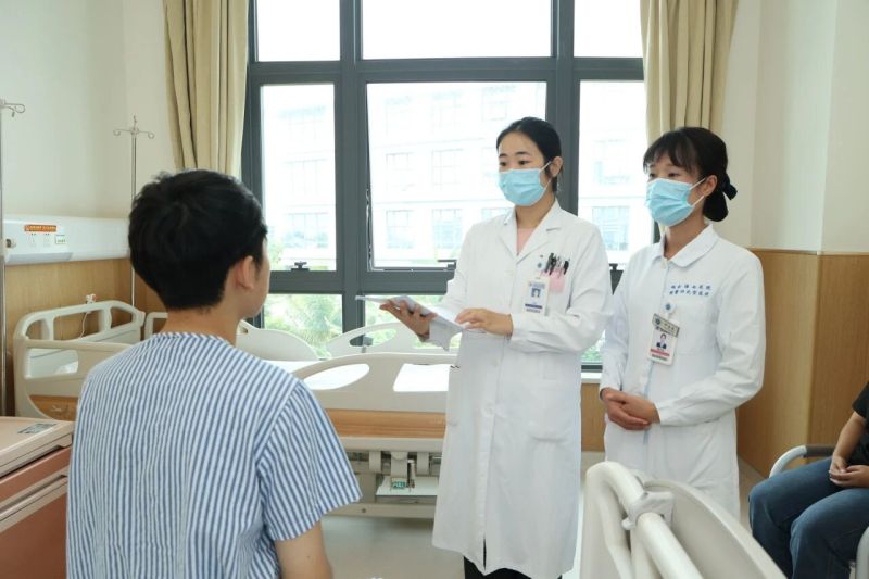 两位医生在病房与一位患者交谈