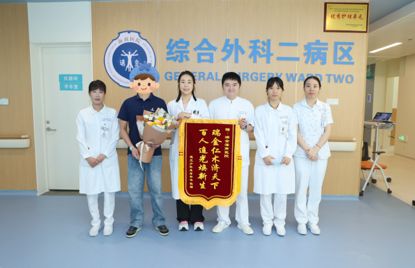 医护人员与一位患者手持鲜花和锦旗在病房合影